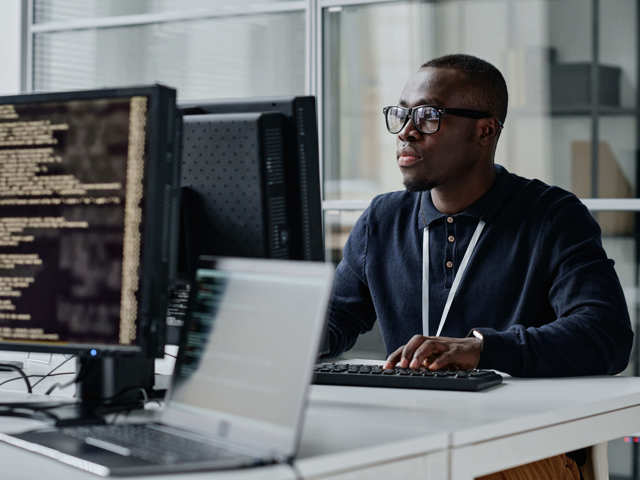 male employee in smart clothing typing on computer