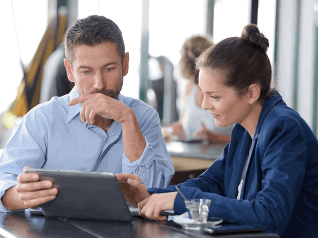 employees in smart clothing looking at tablet computer