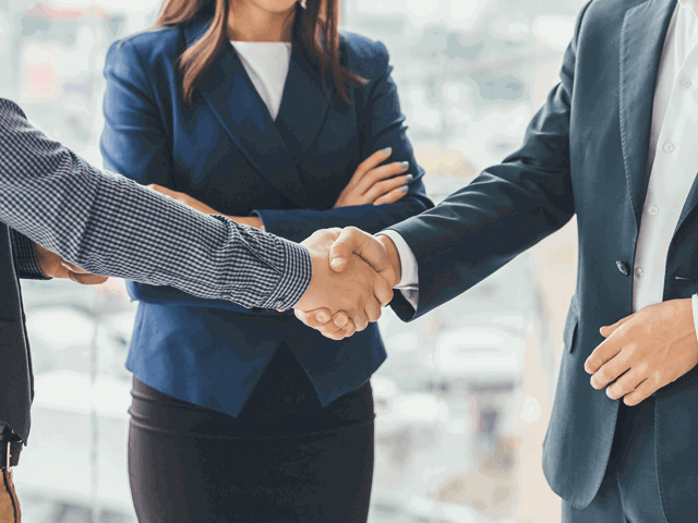 employees in smart clothing shaking hands